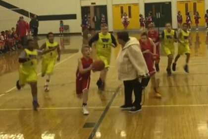 Donna anziana Jay-Walks attraverso il campo da basket a metà partita in video esilaranti