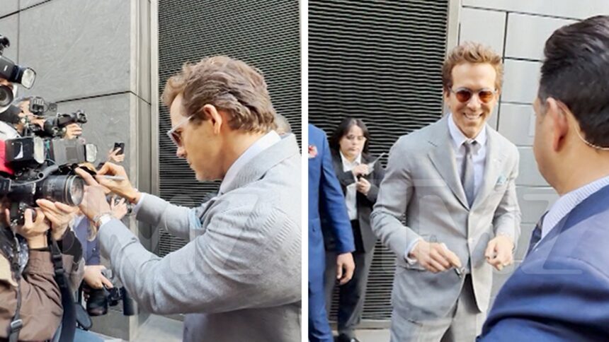 Ryan Reynolds finge di firmare le telecamere paparazzi in "un altro semplice favore" evento
