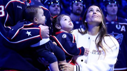 COLUMBUS, OHIO - OCTOBER 15:  Sean Monahan #23 of the Columbus Blue Jackets stands on the ice while holding former Columbus Blue Jackets player Johnny Gaudreaus son, Johnny Jr, along side Gaudreaus wife and daughter, Meredith and Noah, and his brother-in-law Eddie Morris, during a remembrance ceremony prior to the start of the game against the Florida Panthers at Nationwide Arena on October 15, 2024 in Columbus, Ohio. Gaudreau and his brother Matthew were killed when hit by a suspected drunk driver on August 29, 2024.(Photo by Kirk Irwin/NHLI via Getty Images)