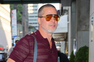 Brad Pitt indossa pantaloni rossi di camicia e neon mentre arrivi a New York