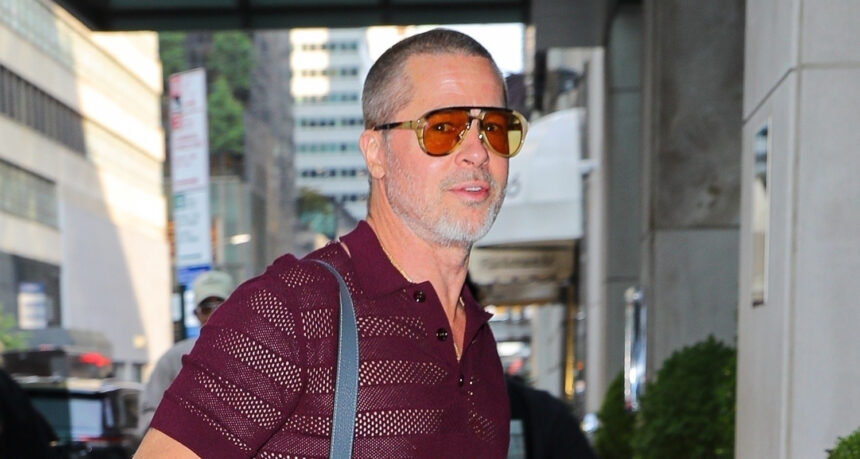 Brad Pitt indossa pantaloni rossi di camicia e neon mentre arrivi a New York