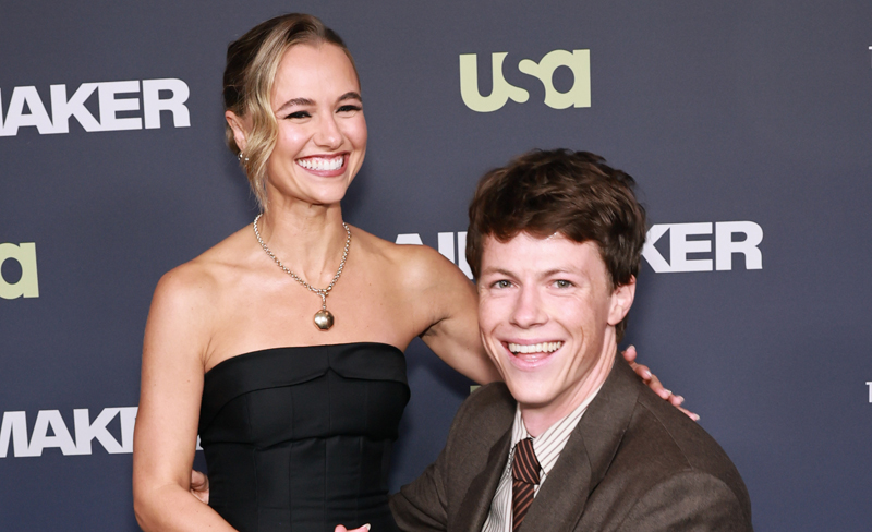 La star di "The Rainmaker" Milo Callaghan si piega fino all'altezza di Madison Iseman alla loro premiere del tappeto rosso!