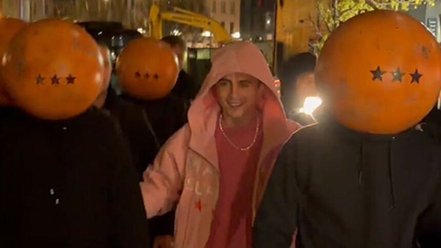 Timothée Chalamet al pop-up "Marty Supreme" con una banda di copricapi da ping-pong, in video